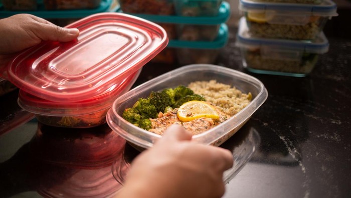 Filipino Man putting away meal prep containersSalmon