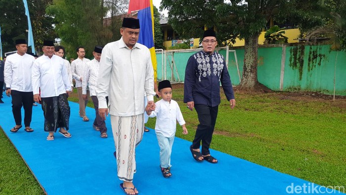 Bobby Nasution menggandeng putranya Ketua Nahyan sebelum salat Id di Lapangan Sejati Medan (Goklas Wisely/detikcom)