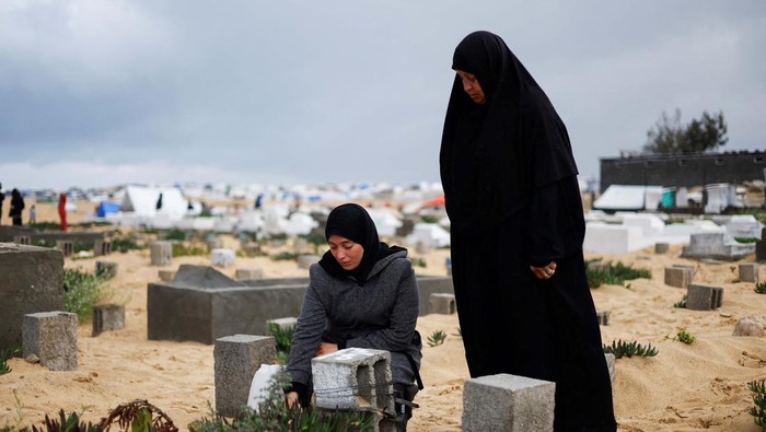 Palestinians visit the graves of people who were killed in the ongoing conflict between Israel and Palestinian Islamist group Hamas, on the day of Eid al-Fitr, in Gaza Strip, April 10, 2024. REUTERS/Mahmoud Issa