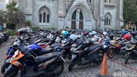 Umat Muslim yang salat id di Masjid Istiqlal memarkirkan kendaraanya di halaman Katedral yang berada persis di seberang pintu masuk Masjid Istiqlal. Sejumlah petugas internal dari Gereja Katedral Jakarta bersiaga memandu masyarakat yang hendak parkir. (Rumondang Naibaho/detikcom)