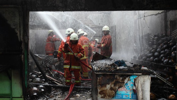 Kebakaran rumah di Surabaya Petugas Dinas Pemadam Kebakaran dan Penyelamatan (DPKP) Kota Surabaya melakukan pembasahan rumah yang terbakar di Jalan Kedung Cowek, Surabaya, Jawa Timur, Rabu (10/4/2024). Pihak DPKP Kota Surabaya mengerahkan 11 unit kendaraan pemadam kebakaran untuk memadamkan kebakaran rumah yang digunakan sebagai tempat usaha penjualan bakso dan diduga kebakaran berawal dari pengisian bensin (bahan bakar minyak) ke tangki sepeda motor di dalam rumah itu yang tumpah dan tersulut api kompor sehingga menyebabkan kebakaran. ANTARA FOTO/Didik Suhartono/foc.