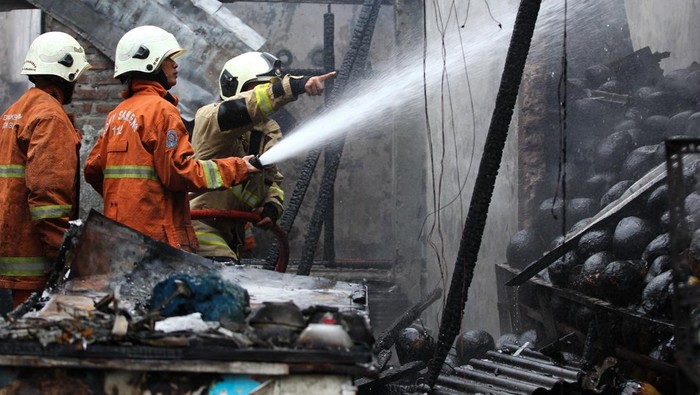 Kebakaran rumah di Surabaya Petugas Dinas Pemadam Kebakaran dan Penyelamatan (DPKP) Kota Surabaya melakukan pembasahan rumah yang terbakar di Jalan Kedung Cowek, Surabaya, Jawa Timur, Rabu (10/4/2024). Pihak DPKP Kota Surabaya mengerahkan 11 unit kendaraan pemadam kebakaran untuk memadamkan kebakaran rumah yang digunakan sebagai tempat usaha penjualan bakso dan diduga kebakaran berawal dari pengisian bensin (bahan bakar minyak) ke tangki sepeda motor di dalam rumah itu yang tumpah dan tersulut api kompor sehingga menyebabkan kebakaran. ANTARA FOTO/Didik Suhartono/foc.