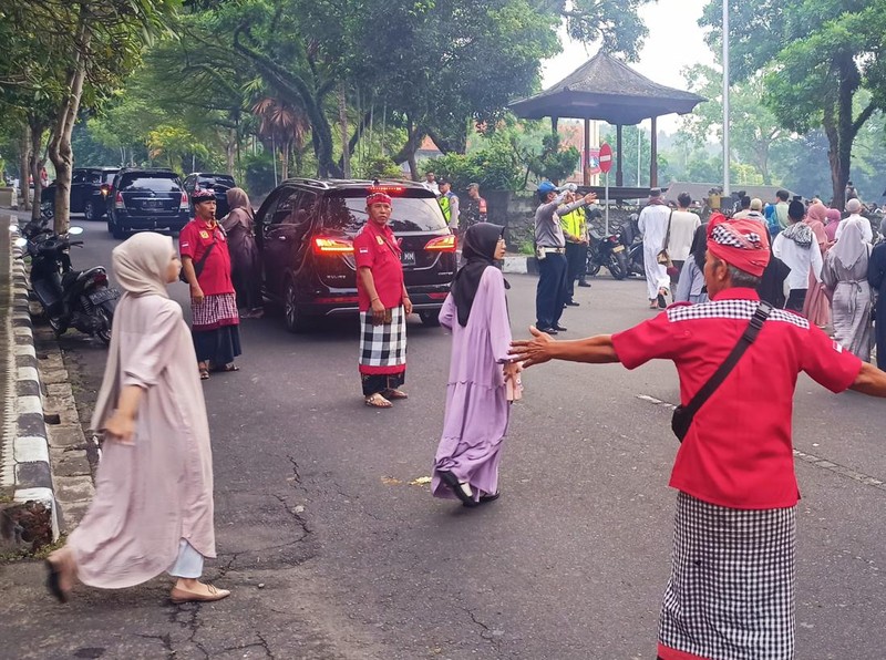 Pecalang berjaga di Lapangan Tanah Aron, Amlapura, Karangasem, Bali, pada Rabu (10/4/2024). Mereka membantu jemaah salat Idul Fitri menyeberang jalan.