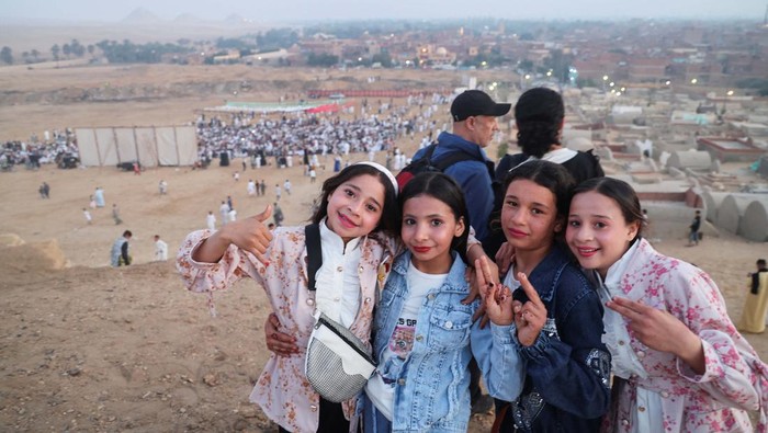 Potret Salat Eid di Kompleks Pekuburan Mesir Kuno di Giza Egyptian Muslim girls pose for a photo as they celebrate Eid al-Fitr, marking the end of the holy fasting month of Ramadan, at the village of Abu Sir, an ancient Egyptian necropolis Pyramids Complex site in the Western Desert at Al Badrashen, in the Giza Governorate, Egypt April 10, 2024. REUTERS/Amr Abdallah Dalsh