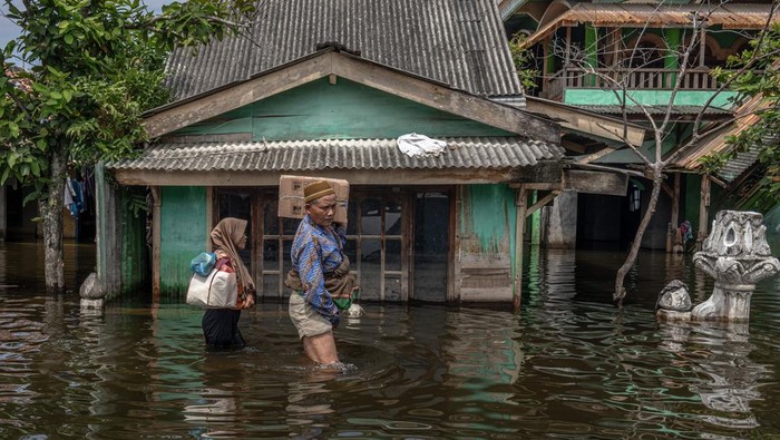 Suasana Lebaran di tengah banjir Demak Warga melewati jalan desa yang terendam banjir untuk merayakan Lebaran bersama keluarga di Desa Sayung, Kecamatan Sayung, Kabupaten Demak, Jawa Tengah, Rabu (10/4/2024). Banjir yang merendam desa setempat selama 28 hari sejak Rabu (13/3) akibat luapan Sungai Dombo-Sayung yang tak mampu menampung debit aliran air karena curah hujan tinggi itu belum surut dengan ketinggian banjir bervariasi hingga mencapai 70 sentimeter, sehingga mengganggu aktivitas serta mobilitas warga dalam merayakan Hari Raya Idul Fitri 1 Syawal 1445 H. Warga berharap kepada Pemkab Demak agar menambah jumlah pompa air yang beroperasi agar banjir cepat surut. ANTARA FOTO/Aji Styawan/foc.