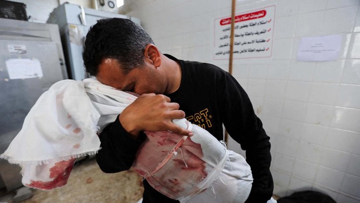 SENSITIVE MATERIAL. THIS IMAGE MAY OFFEND OR DISTURB Palestinian mourners react near the body of a child killed in an Israeli strike, amid the ongoing conflict between Israel and Palestinian Islamist group Hamas, at Al-Aqsa hospital in Deir Al-Balah in the central Gaza Strip, April 10, 2024. REUTERS/Ramadan Abed