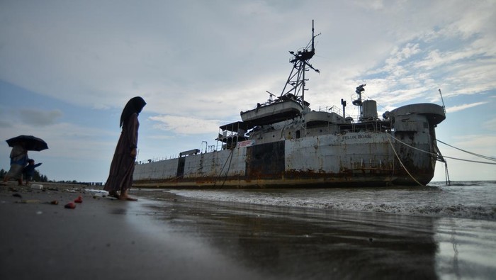 Wisata eks KRI Teluk Bone terdampar di Pariaman Pengunjung melihat eks KRI Teluk Bone 511 yang terdampar di Pantai Pariaman, Sumatera Barat, Rabu (10/4/2024). Eks kapal perang yang sebelumnya dalam kondisi terbengkalai di laut itu diihempas ombak hingga terdampar di tepi pantai dan menjadi objek wisata dadakan terutama saat liburan lebaran. ANTARA FOTO/Iggoy el Fitra/foc.