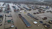 Pemandangan drone menunjukkan kawasan permukiman yang banjir dan sungai Ural di pemukiman Ivanovskoe, wilayah Orenburg, Rusia, Kamis (11/4).