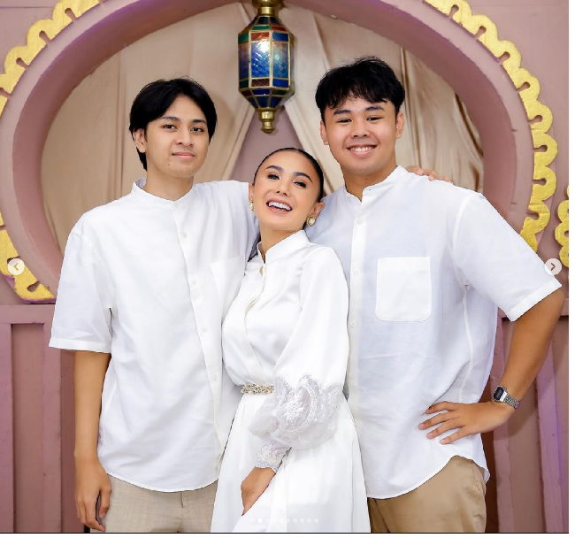 Kakak Krisdayanti, Yuni Shara, juga memakai dress shimmer serupa dengan adiknya. Hanya saja baju shimmer Yuni hadir dalam warna berbeda yaitu putih. Yuni berpose bersama kedua putranya yang juga memakai baju putih. Foto: Dok. Instagram