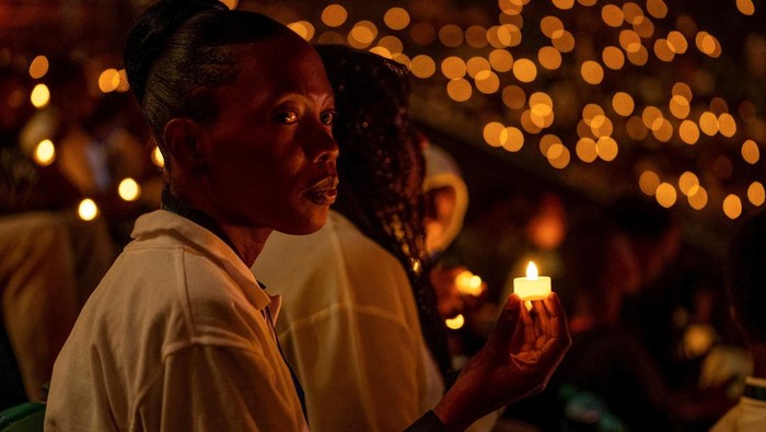 Nyala Lilin Peringati 30 Tahun Genosida di Rwanda Participants hold a candle light night vigil during a commemoration event, known as