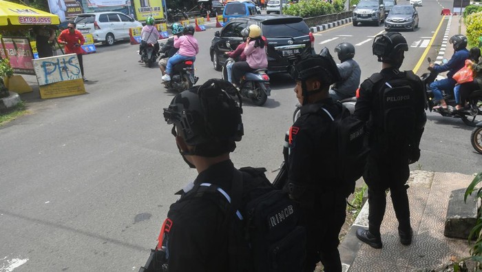 Personel Brimob Polri berjaga di Simpang Gadog, Kabupaten Bogor, Jawa Barat, Kamis (11/4/2024). Sebanyak 350 personel gabungan yang terdiri dari TNI, Polri, Satpol PP, Dishub, BPBD dan relawan Pramuka Kabupaten Bogor disebar untuk pengamanan di sepanjang jalur wisata Puncak saat libur Idul Fitri 1445 Hijriyah. ANTARA FOTO/Arif Firmansyah/nym.