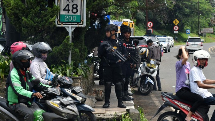Personel Brimob Polri berjaga di Simpang Gadog, Kabupaten Bogor, Jawa Barat, Kamis (11/4/2024). Sebanyak 350 personel gabungan yang terdiri dari TNI, Polri, Satpol PP, Dishub, BPBD dan relawan Pramuka Kabupaten Bogor disebar untuk pengamanan di sepanjang jalur wisata Puncak saat libur Idul Fitri 1445 Hijriyah. ANTARA FOTO/Arif Firmansyah/nym.