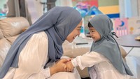 Keduanya kompak mengenakan busana putih dan kerudung abu-abu. Klop banget! (Foto: dok. Instagram @riaricis)