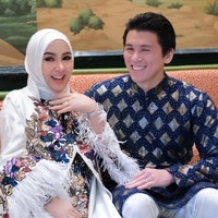 Selalu stylish seperti biasa, Syahrini tampil mengenakan dress panjang berwarna putih. Dress tersebut dipercantik dengan motif bunga warna-warni pada bagian tengahnya dan rubai-rumbai pada bagian lengannya. Sementara sang suami mengenakan baju kurta bermotif warna biru tua dipadukan celana panjang putih. Foto: Instagram/@princessyahrini