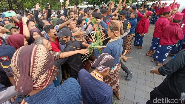 Warga antusias menerima bagian gunungan yang dibagikan para abdi dalem Karaton Ngayogyakarta Hadiningrat di halaman Masjid Gede, Kamis (11/4/2024).