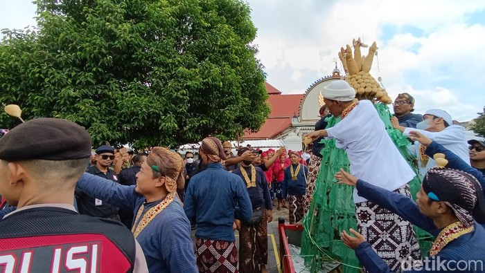 Warga antusias menerima bagian gunungan yang dibagikan para abdi dalem Karaton Ngayogyakarta Hadiningrat di halaman Masjid Gede, Kamis (11/4/2024).