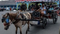 Wisatawan naik delman sewaan saat berkunjung ke kawasan Keraton Kasunanan Surakarta Hadiningrat di Solo, Jawa Tengah, Kamis (11/4/2024).