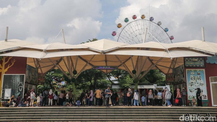 Sejumlah wisatawan mengantre menaiki kendaraan pengantar ke anjungan-anjungan provinsi dan museum di Taman Mini Indonesia Indah (TMII), Jakarta, Jumat (12/4/2024). Pada hari ketiga lebaran, TMII diprediksi dipadati lebih puluhan ribu orang wisatawan yang akan datang.