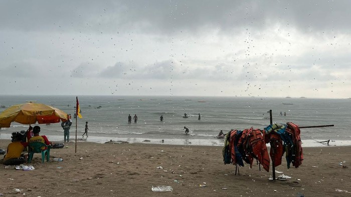 Kawasan objek wisata Pantai Carita di Kabupaten Pandeglang, Banten, diguyur hujan. Meski begitu, para wisatawan tetap antusias berlibur di pantai,  Jumat (12/4/2024).