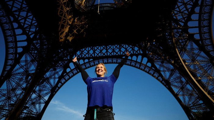 Athlete and Olympics torch bearer Anouk Garnier climbs a 110-meter-long rope launched in the center of the Eiffel Tower square to reach the 2nd floor and to attempt to break the world record for rope climbing, in Paris, France, April 10, 2024. REUTERS/Sarah Meyssonnier      TPX IMAGES OF THE DAY