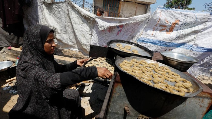 A displaced Palestinian family makes traditional cakes as they prepare for the Eid al-Fitr holiday which marks the end of the Muslim holy fasting month of Ramadan, amid the ongoing conflict between Israel and Hamas, at a tent camp in Rafah, in the southern Gaza Strip, April 8, 2024. REUTERS/Mohammed Salem