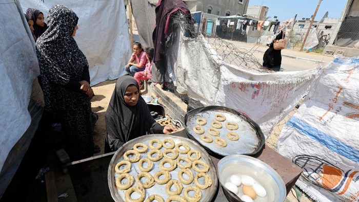 Kue Cincin Temani Warga Gaza Rayakan Idul Fitri di Pengungsian A displaced Palestinian family makes traditional cakes as they prepare for the Eid al-Fitr holiday which marks the end of the Muslim holy fasting month of Ramadan, amid the ongoing conflict between Israel and Hamas, at a tent camp in Rafah, in the southern Gaza Strip, April 8, 2024. REUTERS/Mohammed Salem