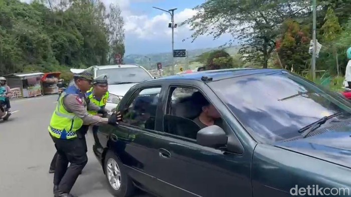 Pasukan drogban Polres Magetan bantuk pengendara mendorong mobil mogok.