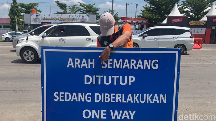 Petugas memasang rambu peringatan pemberlakuan one way, Sabtu (13/4/2024)
