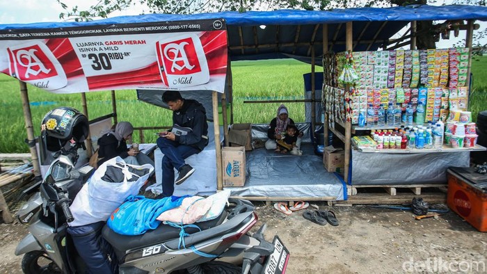 Sejenak Melepas Lelah di Depan Hamparan Sawah Karawang Sejumlah warga beristirahat di jalan Lingkar Tanjungpura, Karawang, Sabtu (13/4/2024).