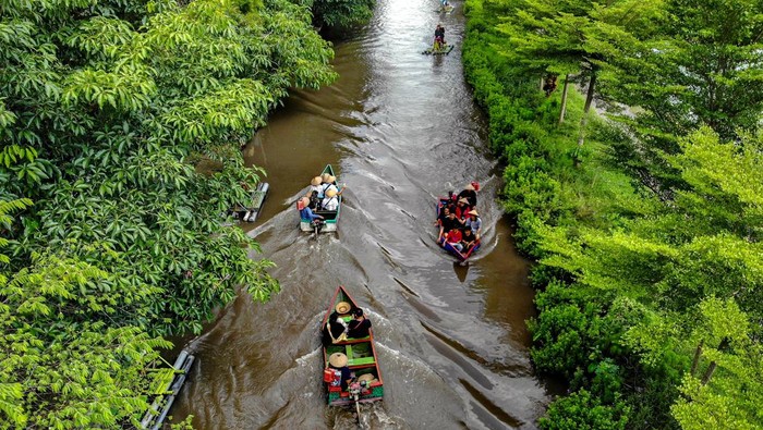Serunya Libur Lebaran di Wisata Irigasi Persawahan Nganjuk Foto udara sejumlah pengunjung menaiki perahu di Wisata Tani Betet, Ngronggot, Nganjuk, Jawa Timur, Sabtu (13/4/2024). Kunjungan wisata di saluran irigasi persawahan yang dikelola warga setempat menjadi obyek wisata itu meningkat dari hari biasanya yakni sekitar 100 per hari menjadi sekitar 500 pengunjung per hari saat libur Lebaran. ANTARA FOTO/Muhammad Mada/nz