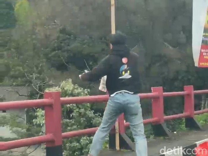 Tangkapan layar video pria buang sampah ke sungai di Jalur Puncak, Cianjur.