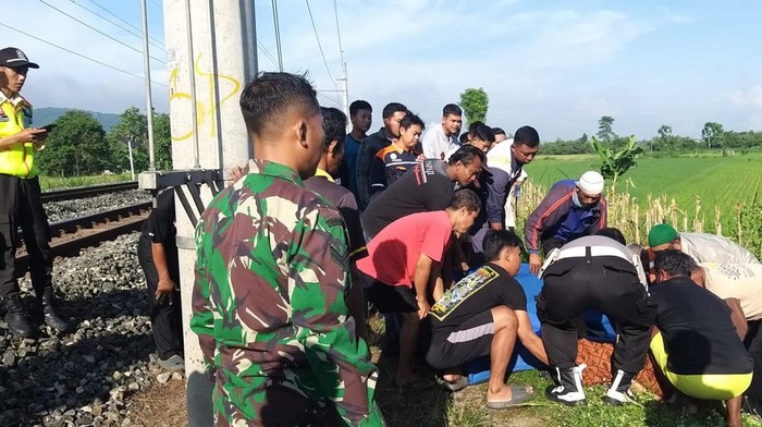 Warga mengeevakuasi korban tewas tertabrak kereta api di Desa Sanggrahan, Klaten