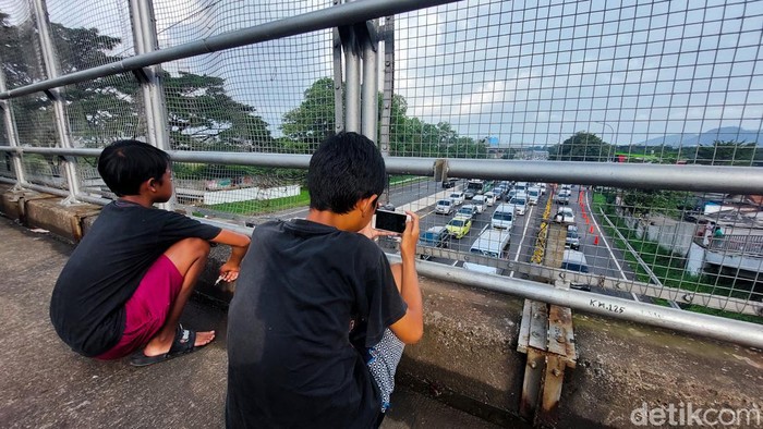Bus mania cilik asal Cimahi berburu foto di atas jembatan jalan tol.