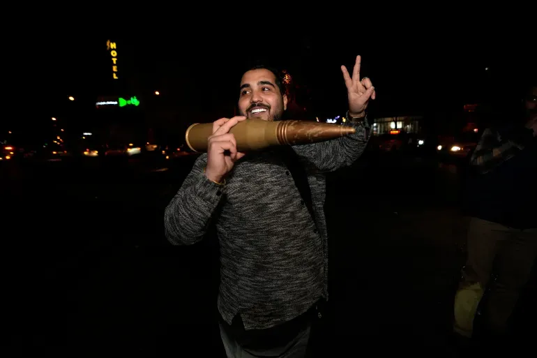 Demonstrasi di Tehran dukung serangan Iran ke Israel. Pria mengangkat replika peluru misil (Vahid Salemi/AP). Pembentangan bendera Palestina raksasa (Atta Kenare/AFP).