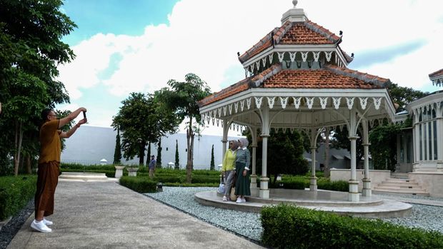 Pengunjung berfoto saat berwisata di Taman Pracima Tuin di kompleks Pura Mangkunegaran, Solo, Jawa Tengah, Sabtu (13/4/2024). Pura Mangkunegaran yang menawarkan wisata sejarah lewat jelajah museum, Taman Pracima Tuin, lokakarya seni dan kuliner tradisional tersebut menjadi salah satu destinasi wisata yang banyak dikunjungi wisatawan saat libur Lebaran di Kota Solo. ANTARAFOTO/Maulana Surya.