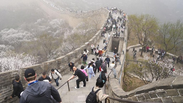Visitors walk on a stretch of the Badaling Great Wall in Beijing, Saturday, April 13, 2024. (AP Photo/Tatan Syuflana)