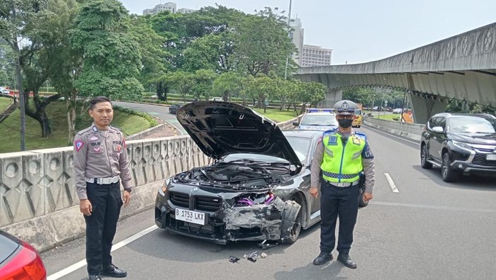 Sedan BMW hitam menabrak pembatas Simpang Susun Semanggi, Jakarta.