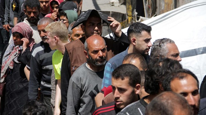 Palestinians gather to buy bread from a bakery which went back into service after being shut down for several months due to the lack of flour and energy, amid the ongoing conflict between Israel and Hamas, in Gaza City, April 14, 2024. REUTERS/Mahmoud Issa