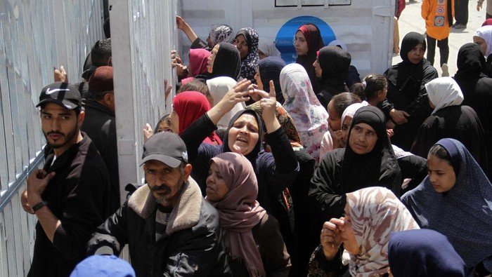 Buka Setelah Tutup Berbulan-bulan, Toko Roti di Gaza Diserbu Warga Palestinians gather to buy bread from a bakery which went back into service after being shut down for several months due to the lack of flour and energy, amid the ongoing conflict between Israel and Hamas, in Gaza City, April 14, 2024. REUTERS/Mahmoud Issa