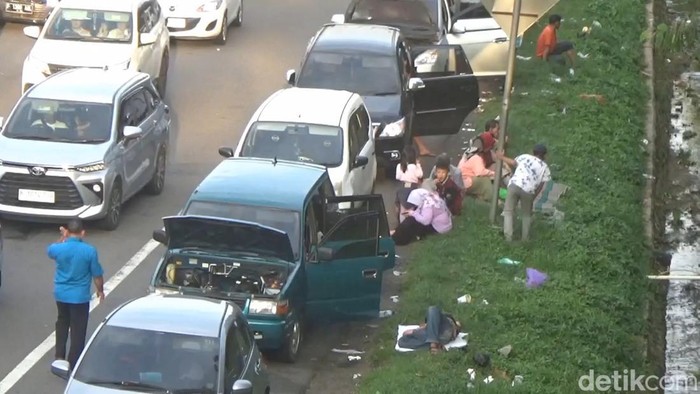Para pemudik melepas lelah di bahu jalan Tol Cikampek KM 72