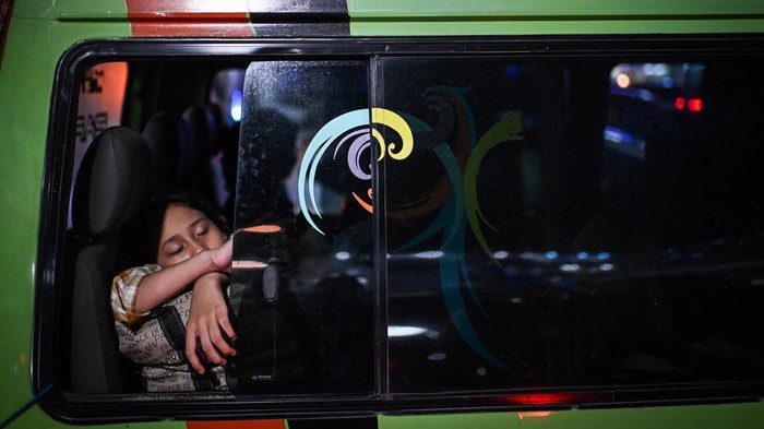 Secuil Kisah Memeluk Rindu Melangkah Pulang Pemudik tertidur di dalam mobil saat menunggu antrean untuk memasuki kapal di Pelabuhan Merak, Cilegon, Banten.