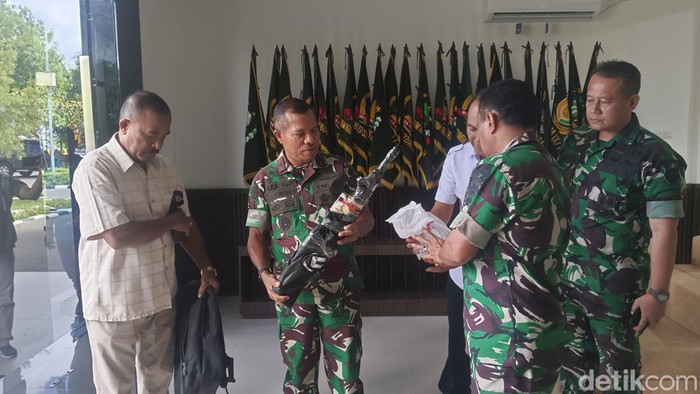 Seorang warga dari perbatasan Indonesia-Timor Leste menyerahkan sepucuk senjata jenis M16 A1 ke Korem 161/Wira Sakti Kupang. (Foto: Yufengki Bria/detikBali)