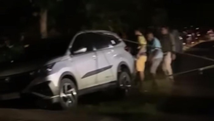Warga saat mencoba mengevakuasi mobil sejenis Alya yang terperosok ke sebuah selokan di Kapanewon Tanjungsari, Kabupaten Gunungkidul.