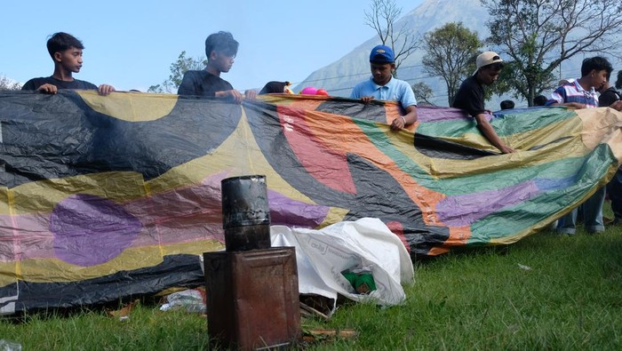 Peserta melipat kembali balon udara saat Festival Balon Wonosobo 2024 di Lapangan Reco, Kertek, Jawa Tengah, Selasa (16/4/2024). Seluruh peserta Festival Balon Wonosobo 2024 di lokasi tersebut gagal menerbangkan balon udara karena terkendala cuaca, yakni angin bertiup kencang. ANTARA FOTO/Anis Efizudin/wpa.