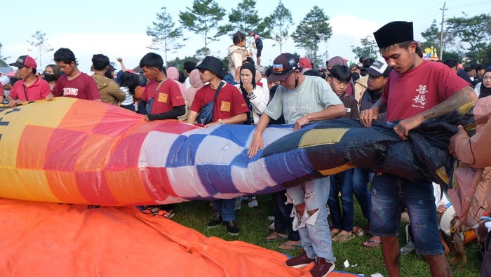 Peserta melipat kembali balon udara saat Festival Balon Wonosobo 2024 di Lapangan Reco, Kertek, Jawa Tengah, Selasa (16/4/2024). Seluruh peserta Festival Balon Wonosobo 2024 di lokasi tersebut gagal menerbangkan balon udara karena terkendala cuaca, yakni angin bertiup kencang. ANTARA FOTO/Anis Efizudin/wpa.
