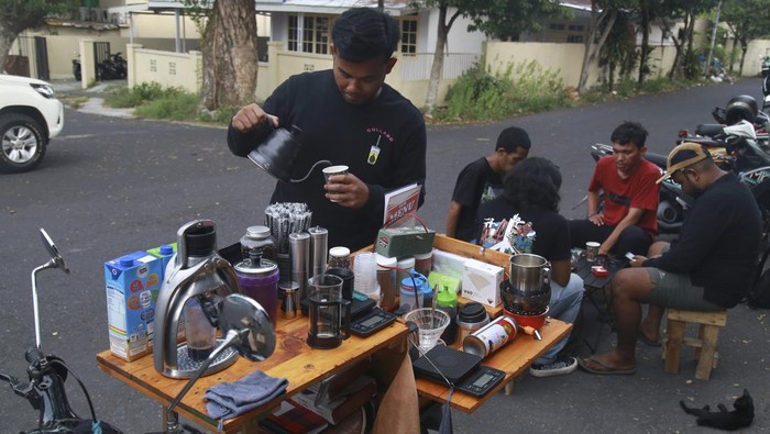Barista Kopi Godahang menyeduh kopi saat berjualan di sekitar Stadion Gelora Kie Raha Ternate, Maluku Utara, Selasa (16/4/2024). Asmar memodifikasi motor klasik Honda C70 miliknya menjadi warung kopi keliling yang mejual berbagai macam kopi ala cafe, dengan harga terjangkau mulai dari Rp15 ribu - Rp18 ribu, meskipun sederhana warung ini cukup diminati kalangan remaja. ANTARA FOTO/Andri Saputra/Spt.