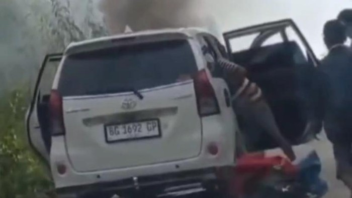 Pemilik Avanza dan penumpang mengevakuasi barang-barang sebelum mobil hangus terbakar.