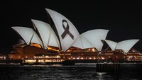 Pita hitam disinari di layar Gedung Opera Sydney pada Senin malam (15/4) untuk menghormati para korban penikaman di mal kota. AP/Mark Baker