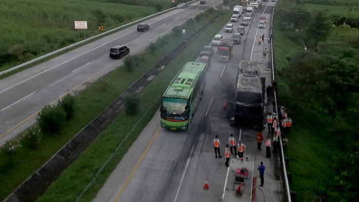 Bus terbakar di Tol Jombang Petugas berdiri di dekat Bus Pahala Kencana nopol B 7426 TK tujuan Bandung-Denpasar yang ludes terbakar di ruas tol Jombang-Mojokerto (Jomo) KM 705 A Desa Blimbing, Kecamatan Kesamben, Kabupaten Jombang, Jawa Timur, Rabu (17/4/2024). Kebakaran bus tersebut diduga disebabkan api dari gesekan pelek dengan beton jalan tol yang sebelumnya mengalami pecah ban, sebanyak 34 penumpang, kenek dan sopir selamat. ANTARA FOTO/Syaiful Arif/rwa.