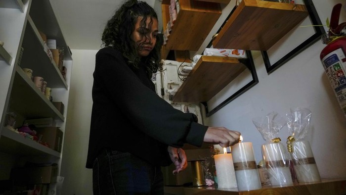 A woman runs across an avenue where traffic lights are not working due to a programed power cut ordered by the ministry of energy, in Quito, Ecuador, Tuesday, April 16, 2024. Ecuador faces electricity rationing due to a prolonged drought and high temperatures that have reduced flows to the main hydroelectric plants. (AP Photo/Dolores Ochoa)